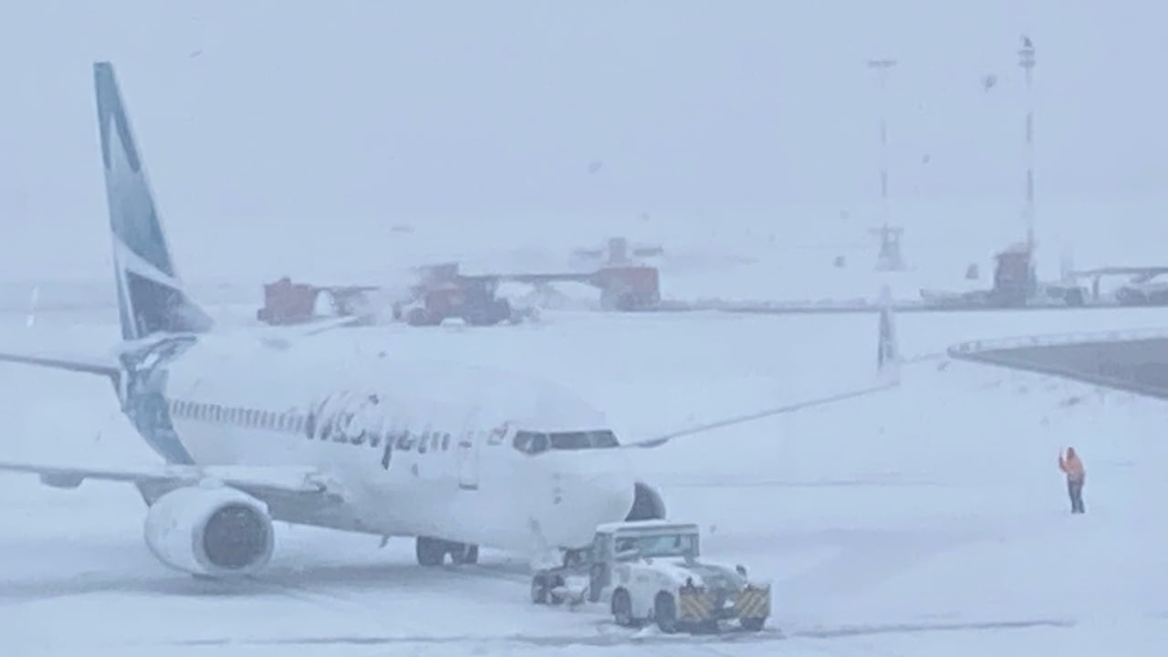 一架巨型喷气式客机停在停机坪上,暴风雪肆虐。